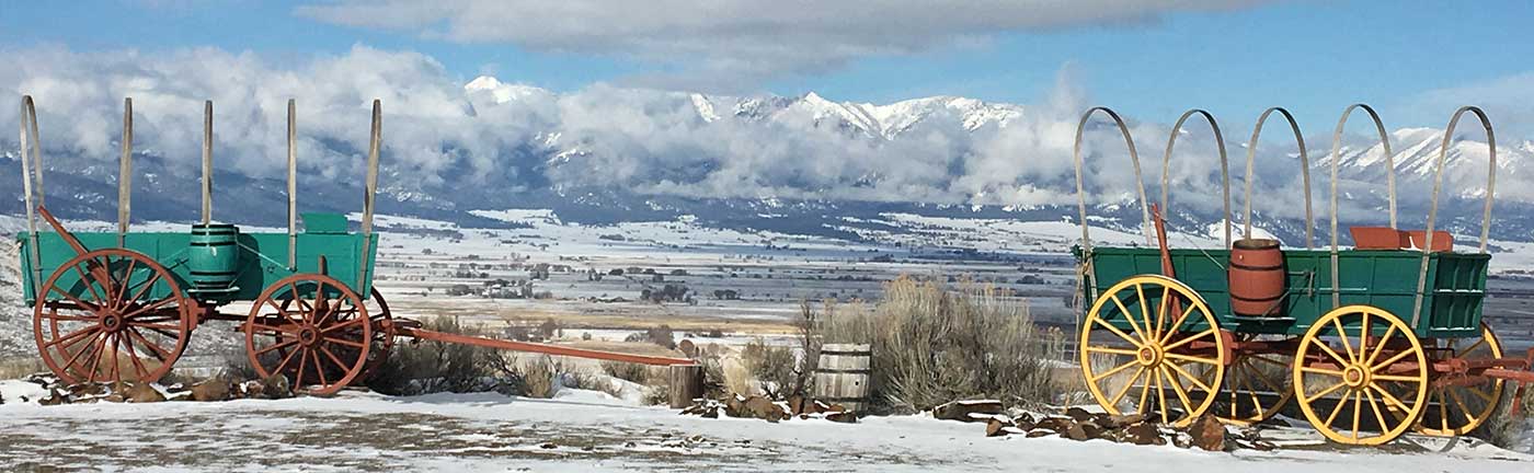 covered wagons in front of a snowy landscape